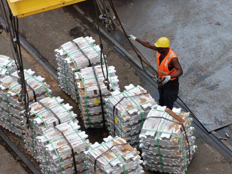 A longshoreman unloads aluminum ingots.