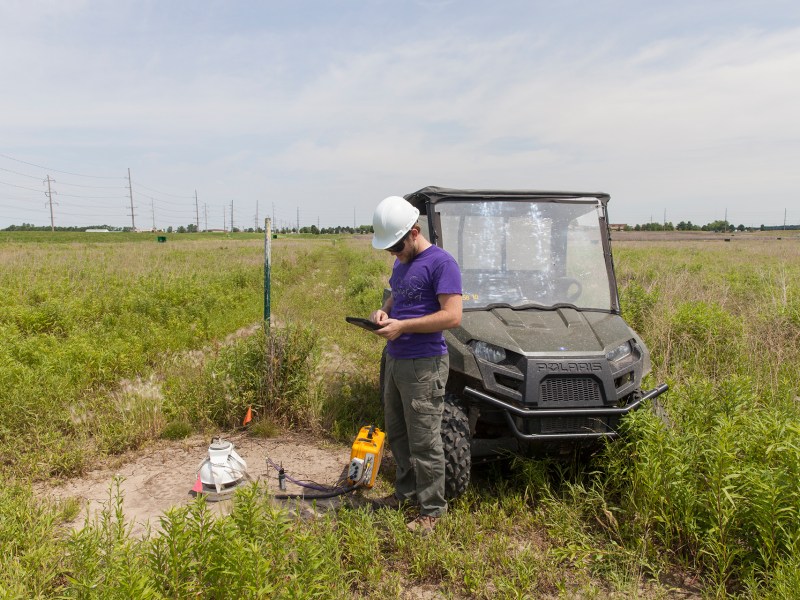 A scientist checks monitoring equipment in an open field at a carbon capture test site in Illinois.