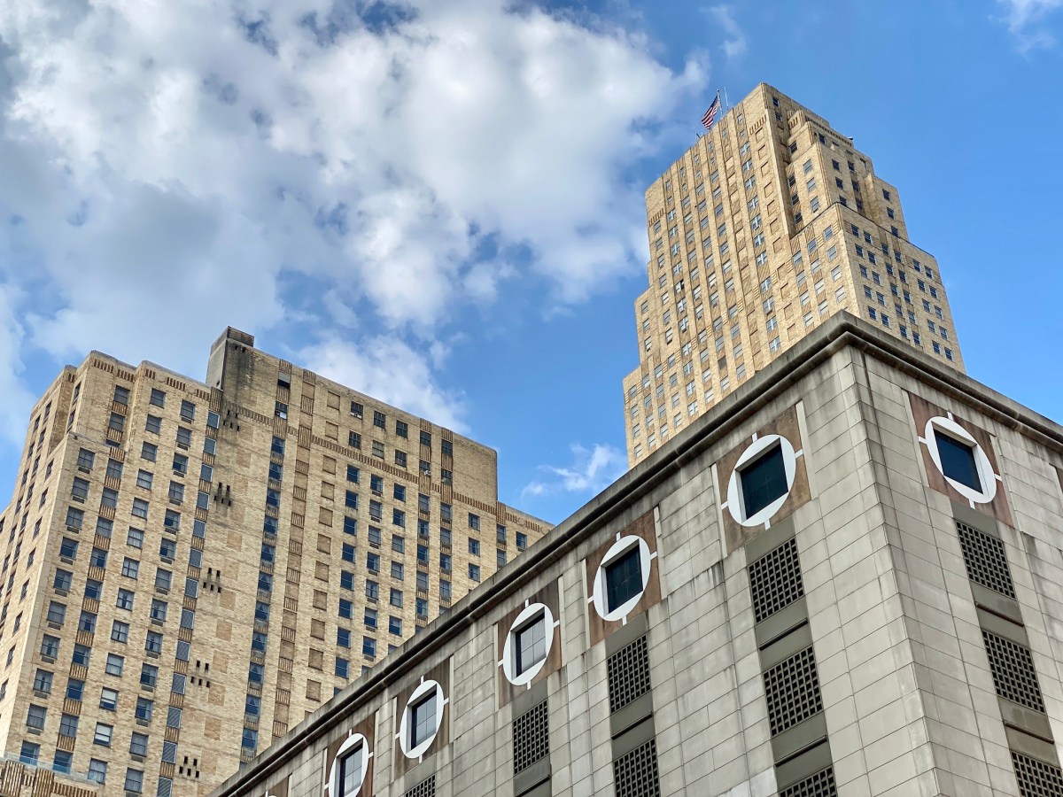 A low-angle photo of historic high-rises in Cincinnati against a blue sky.