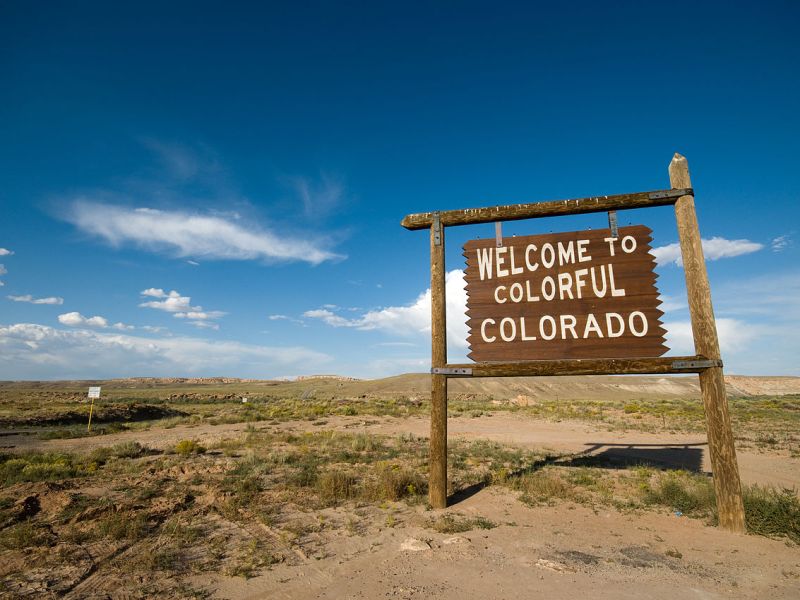 A wooden sign reads "welcome to colorful Colorado."