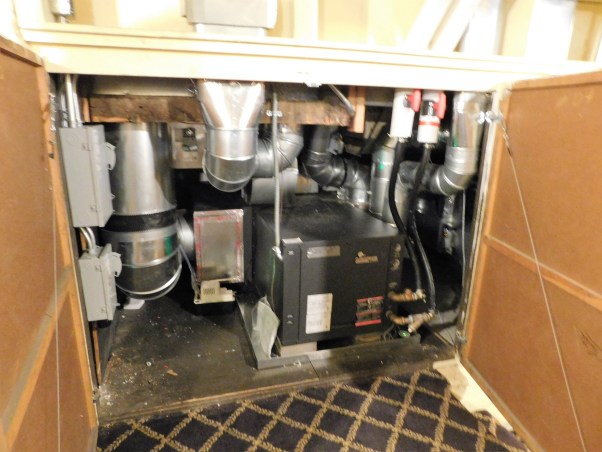 A ground-source heat pump installed in storage area below the main stairs in the Glessner House.