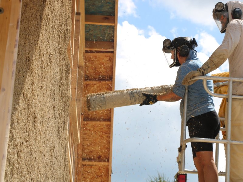 FiberFort's Stephanie Syzmanski, left, applies hempcrete insulation at Michigan's first hemp-based house.