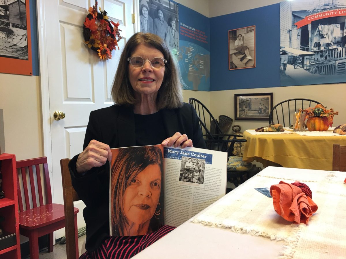 A woman holds up a book in a museum on the mountain coal town of Osage, West Virginia