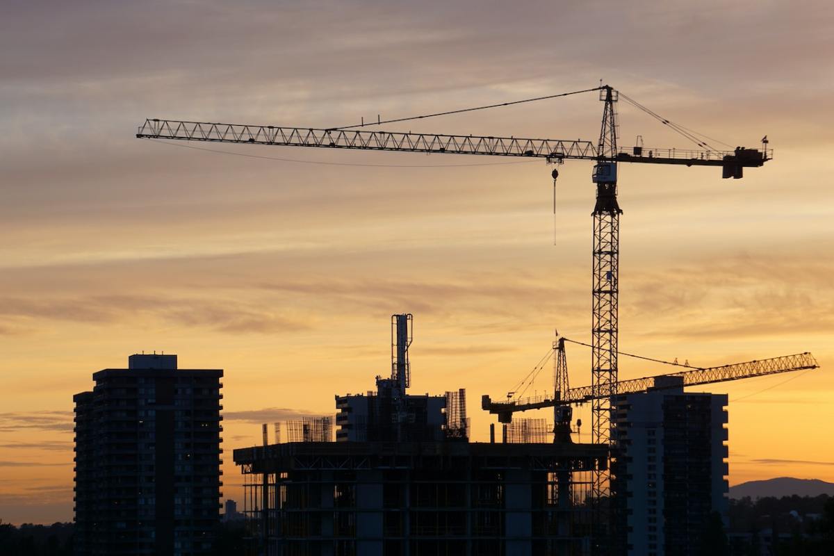 A silhouetted construction scene.