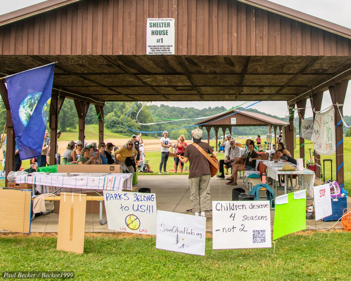 A guitarist performs for an audience of protesters at Salt Fork State Park in Ohio in July, 2023.