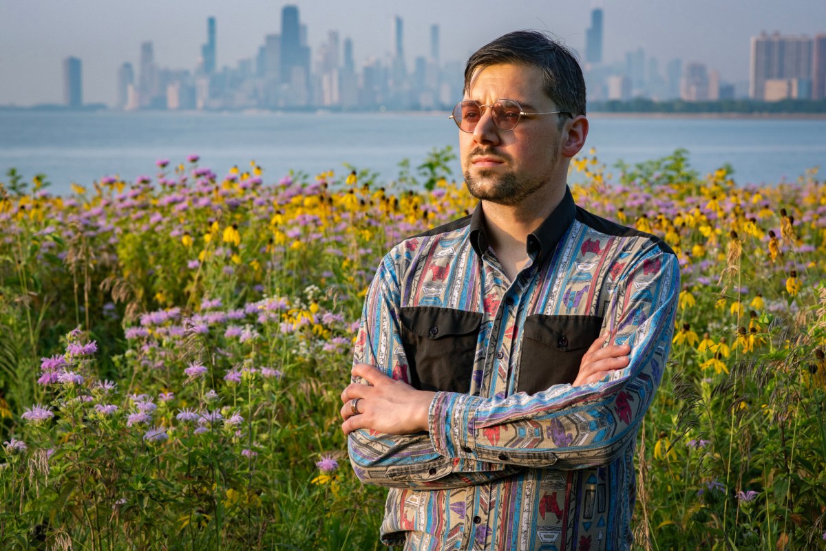 Saxon Metzger stands in a field of wildflowers with the Chicago skyline in the distant background.