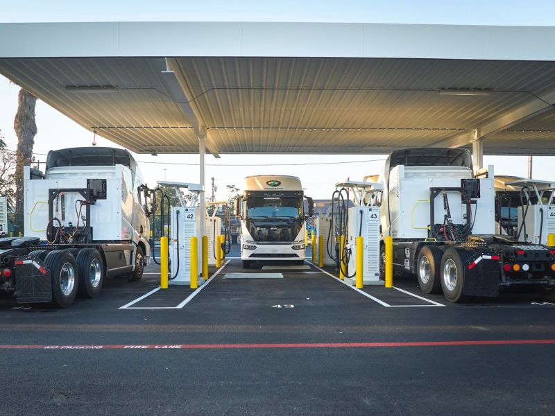 Electric trucks are parked in a charging depot.